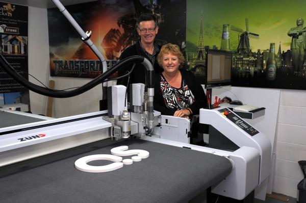 Action Signs owners Suzanne and Bill McKnight in front of the new G3 digital cutter